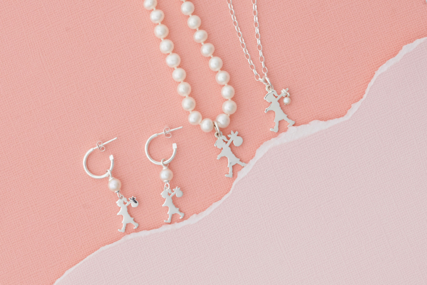 Karen Walker's Girl with a Pearl Earrings, Pearl Necklace, and Sterling Silver Necklace all sit together on a pale pink background, clearly off on their latest adventure!